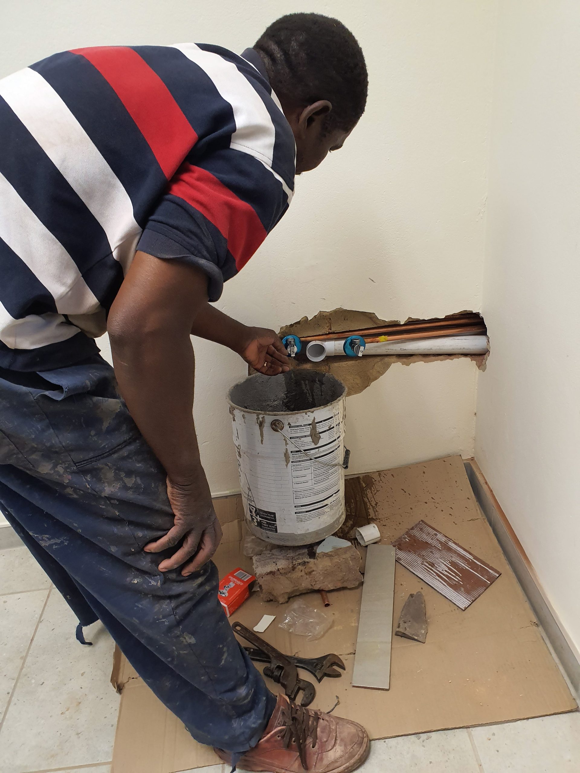 services-02 Man using a power drill for home improvement on a wooden floor with precision.