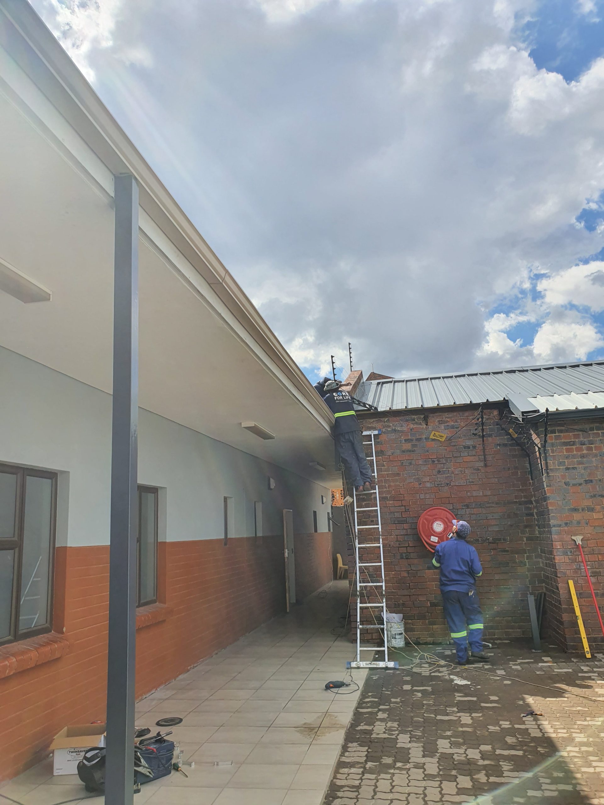 services-03 Two engineers reviewing blueprints in an office, discussing project details.