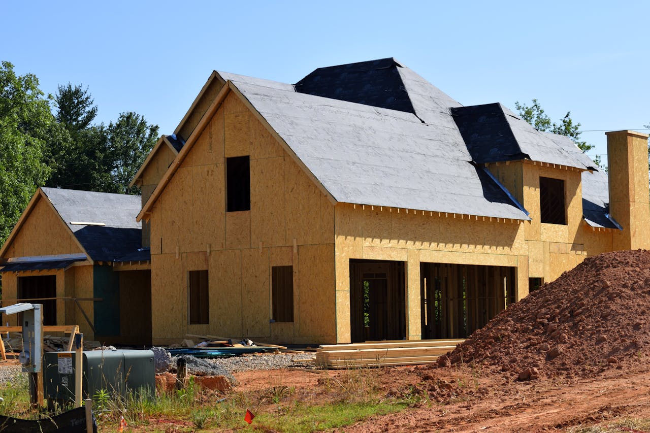 About A partially built wooden house under construction, showcasing its progress and design in daylight.